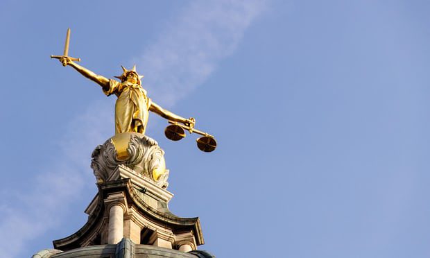 Picture of a blindfolded statue - 'Justice' - holding a sword in her right hand and a set of scales in her left hand.