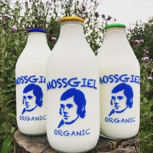 Picture of pint bottles of Mossgiel Whole Milk, Semi-skimmed Milk, and Calf-With-Cow Milk sitting outside