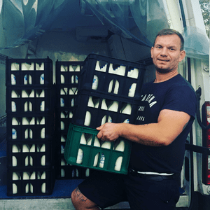 Picture of Konrad loading crates of Milk bottles onto a van.