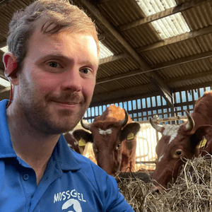 Picture of Bryce Cunningham in the Byre with the Cows.