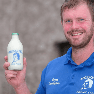 Picture of Bryce Cunningham holding a glass pint bottle of Mossgiel Organic Semi-Skimmed Milk.