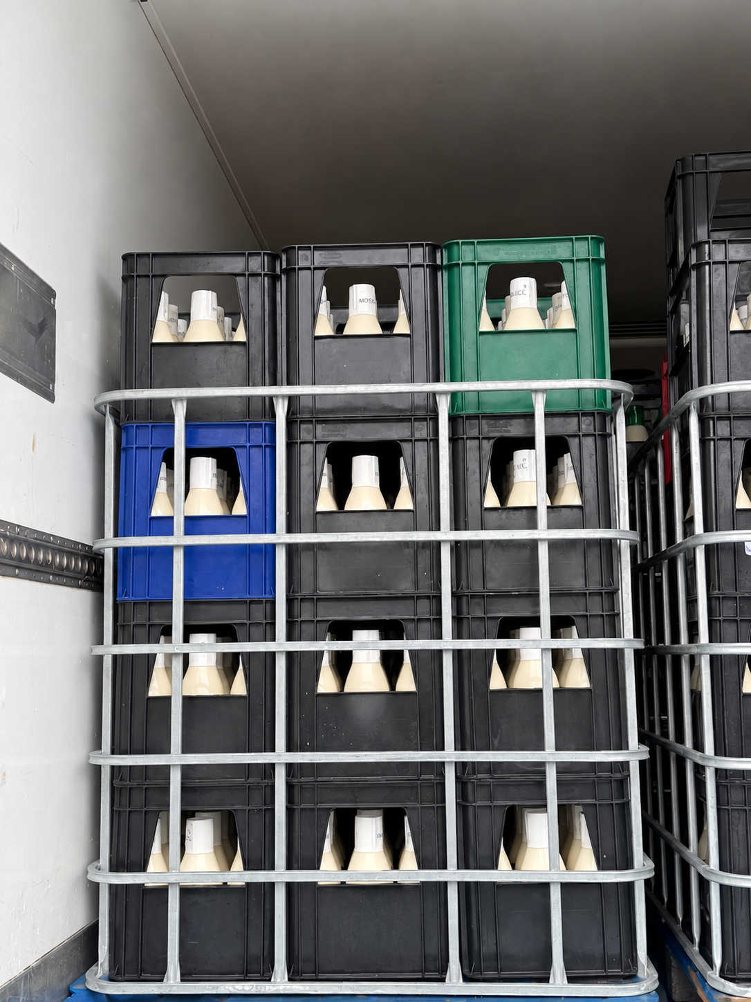 Reusable milk crates secured inside upcycled IBC frames for transport